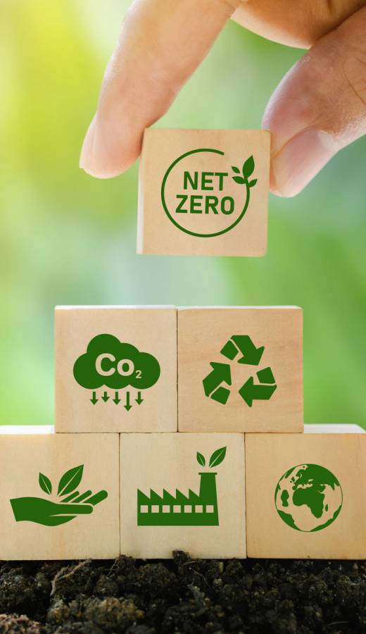 Net Zero and Carbon Neutral Concepts Net Zero Emissions Goals A climate-neutral long-term strategy Ready to put wooden blocks by hand with green net center icon and green icon on gray background.